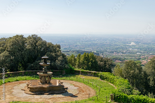 Top view of the panoramic landscape of the valley, the country houses and gardens are visible to the horizon, in the foreground is a stone fountain - part of the garden of an ancient villa