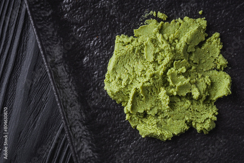 fragrant wasabi powder on a black wooden background photo