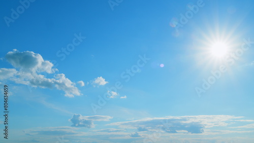 Beautiful blue sky with sunbeams and clouds. Clouds at blue sky background. Sunny cloudscape. Time lapse.