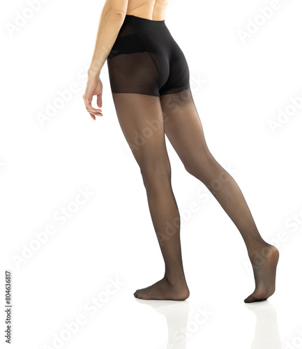 Woman with beautiful long legs and black stockings, isolated on white background. Rear, back view