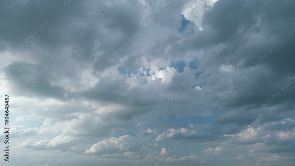 Obraz premium Dramatic sky with gray dark clouds before rain. Powerful cumulus clouds with a dark base. Timelapse.
