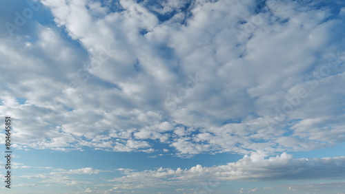 Sky with bautiful silky clouds. Puffy fluffy cumulus and cirrocumulus on different layers clouds. Timelapse. photo