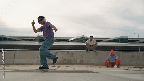 Group of skilled break dancer perform street dance with friend looking and cheering at him. Handsome hipster practice b boy dance at street while listening to music. Outdoor sport 2024. Sprightly.