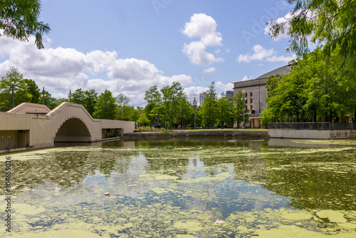 a gorgeous spring landscape at Louis Armstrong Park with lush green trees, plants and grass, a lake, blue sky and clouds in New Orleans Louisiana USA photo