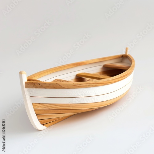 A small wooden boat rests peacefully on a white table photo