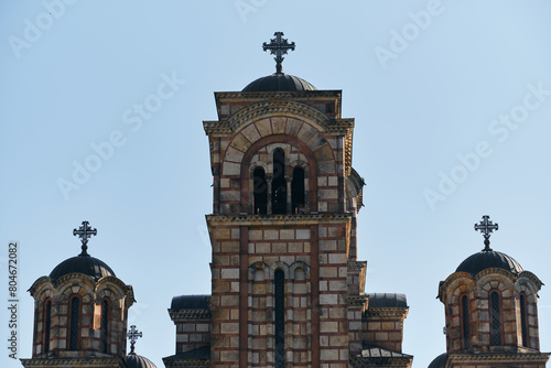 The cross on the dome of St. Mark's Church and blue sunny sky near Tashmaidan Park. Facade of the old temple building. Belgrade, Serbia- 04.28.2024. photo