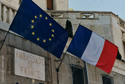 Belgrade, Serbia- 04.28.2024. The exterior of the French embassy in Belgrade, with the French flag and European Union flag above the door. Gold Letters Engraved in to White Marble Stone.