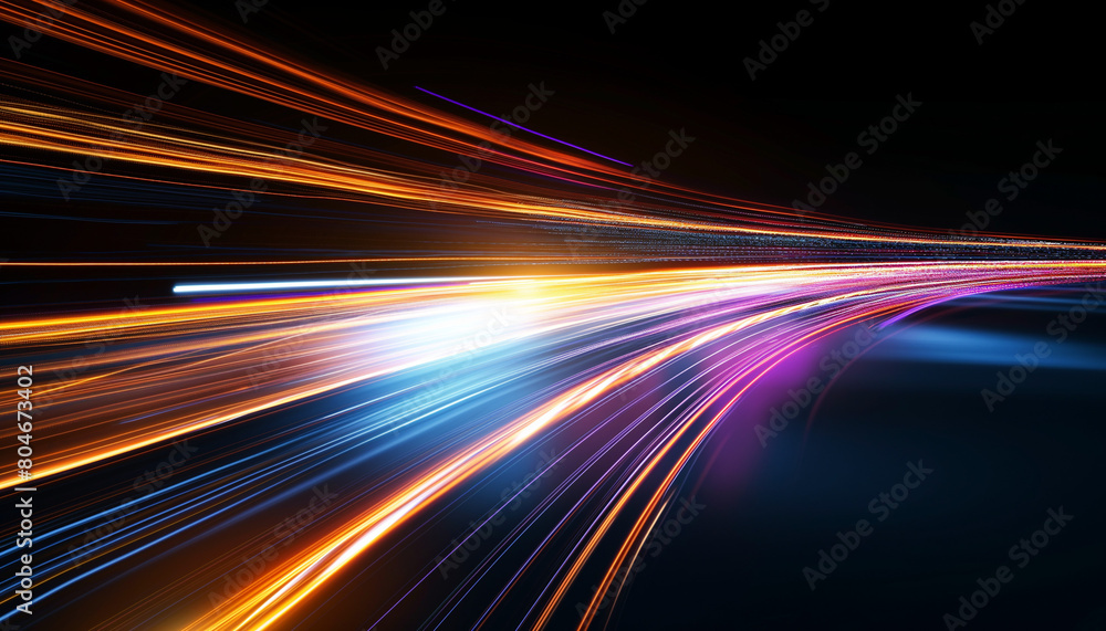 Colorful light streaks blur across a highway at night, creating an abstract motion effect