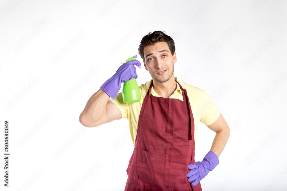 Young handsome male contractor from cleaning service wearing uniform, apron and rubber gloves holding cleaning tools and feeling bad because of exhausting household day isolated on white background Young handsome male contractor from cleaning service wearing uniform, apron and rubber gloves holding cleaning tools and feeling bad because of exhausting household day isolated on white background