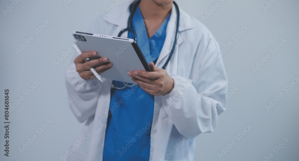 Woman doctor using tablet computer while standing straight in hospital
