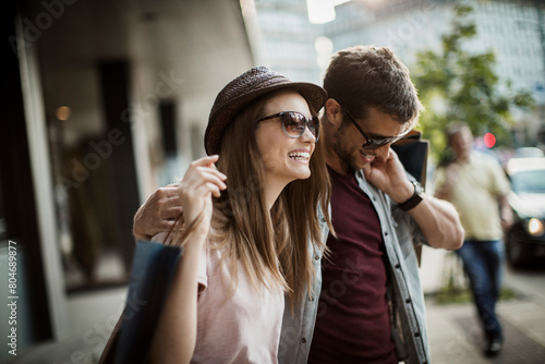 Happy couple shopping and laughing on city street © Geber86