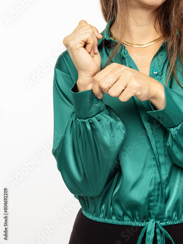 Green silk women's blouse on white background. Button on sleeve © Svetlana