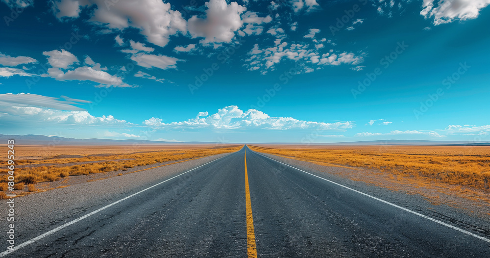 Fototapeta premium the road to the sky, a straight road leading into the distance, clear blue sky with clouds.