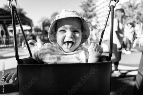 Portrait of a nine month old baby having fun on a swing
