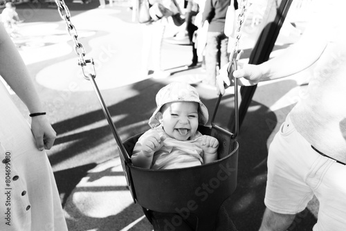 Portrait of a nine month old baby having fun on a swing