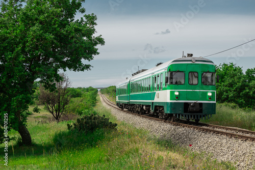 Green train or zeleni vlak, connecting Ljubljana, Slovenia and Pula, Croatia, on its way towards the end station. Picturesque green train in between the istrian scenery and straight track photo