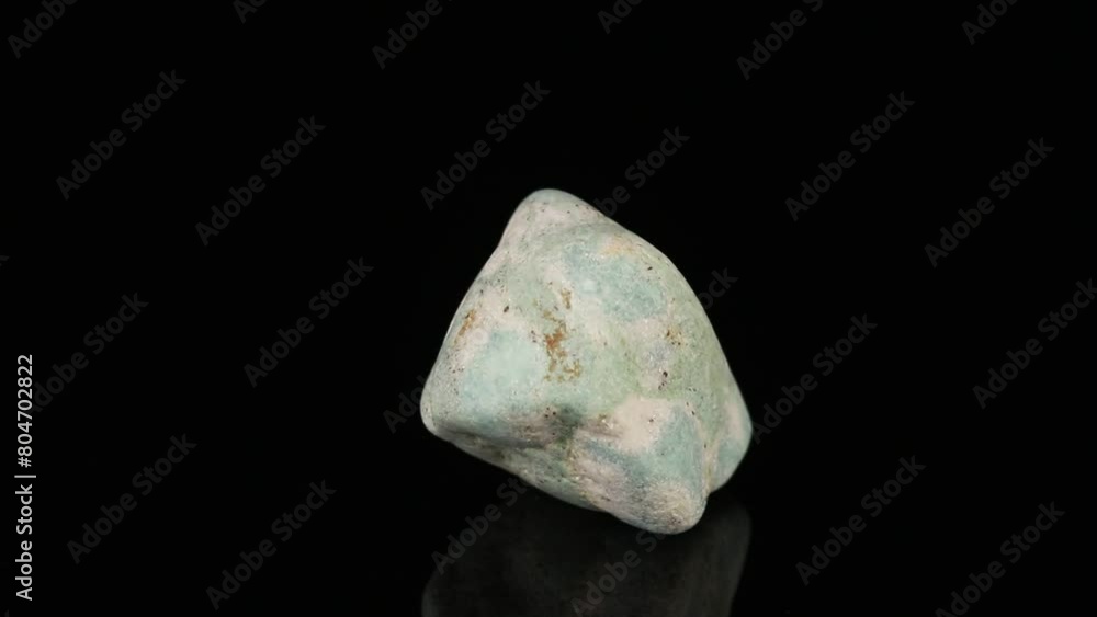 Polished mineral stone zoisite rotates in a circle on a black background Polished mineral stone zoisite rotates in a circle on a black background