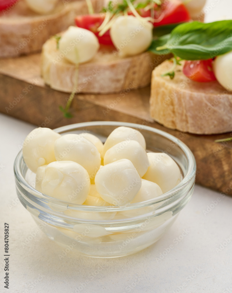 Mozzarella balls in glass bowl on a white background Mozzarella balls in glass bowl on a white background