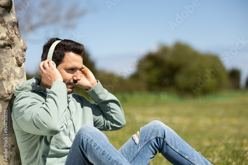 man listening to music resting on the meadow