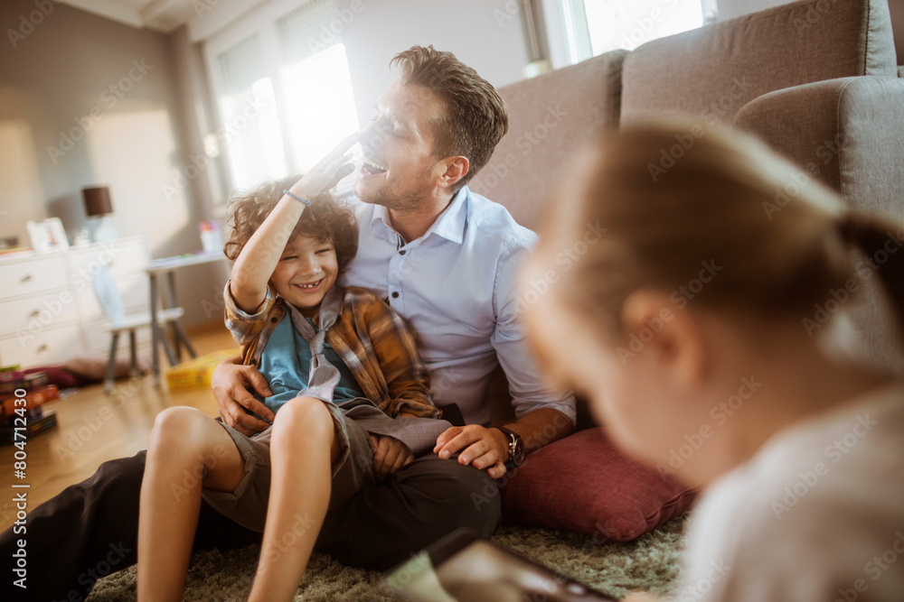 Happy father playing with son and daughter at home Happy father playing with son and daughter at home