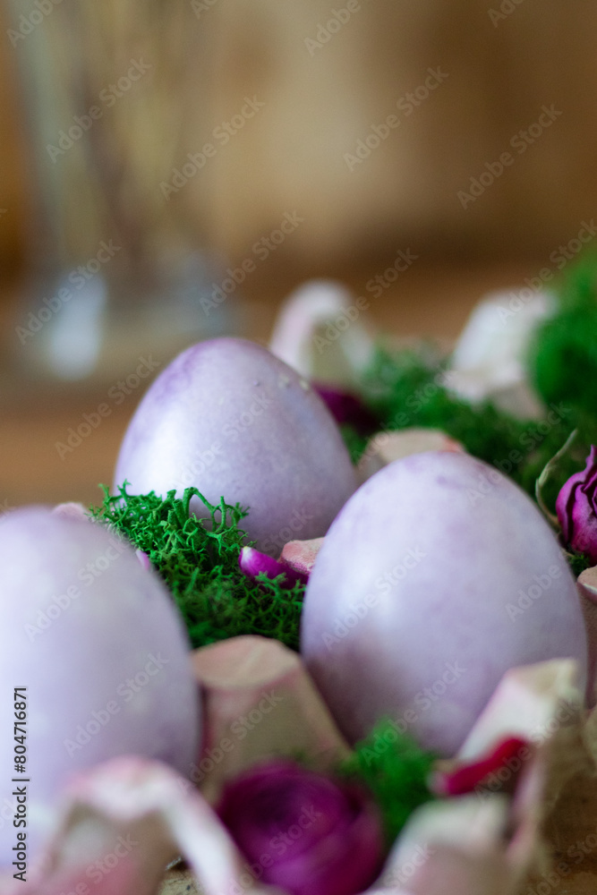Easter colored eggs in a basket with moss Easter colored eggs in a basket with moss
