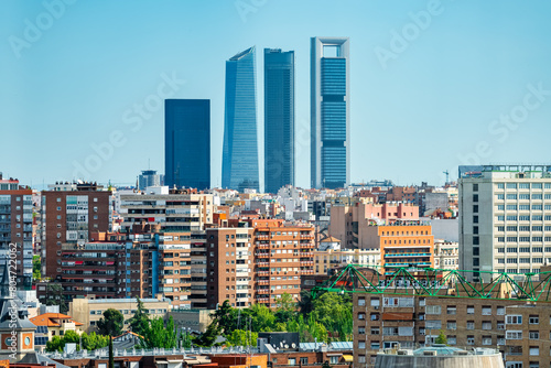 Four skyscraper towers of Madrid emerging among the buildings of the city, Spain.