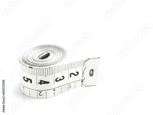 White tailoring background with an isolated rolled centimeter tailor's tape and space for text photo