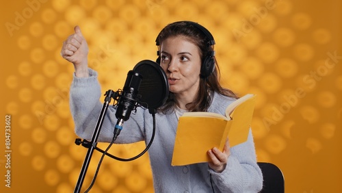Fotografia Voice actor looking to producer off camera to know when to start narrating book, producing audiobook