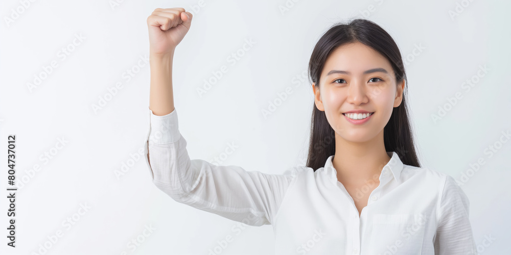Empowered Young Woman in White Raising Fist Signifying Strength and Confidence Empowered Young Woman in White Raising Fist Signifying Strength and Confidence
