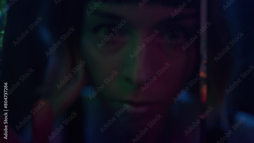 A young woman in the nightclub peeks from behind the glittering curtain A young woman in the nightclub peeks from behind the glittering curtain