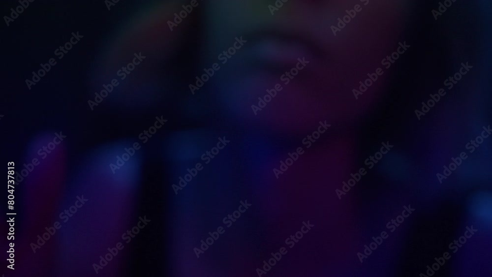 A young woman in the nightclub peeks from behind the curtain A young woman in the nightclub peeks from behind the curtain