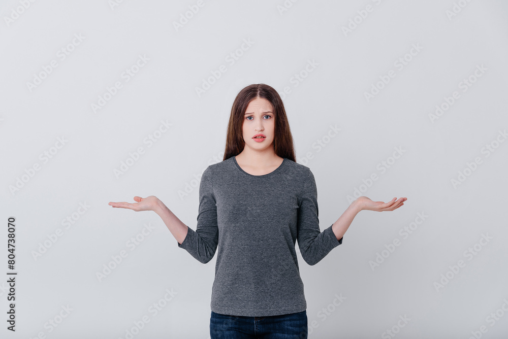 young caucasian beautiful woman in grey sweatshirt being at loss, dont understand anything, i dont know young caucasian beautiful woman in grey sweatshirt being at loss, dont understand anything, i dont know