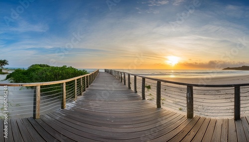 panorama view of footbridge to beach at sunrise