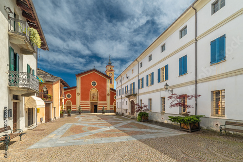 Sanfront, Cuneo, Italy - May 03, 2024: Piazza Ferrero paved with porphyry and stone slabs with the parish church of San Martino photo