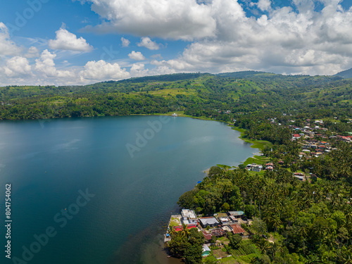 Lake Lanao and small town in lake coast. Mountain green forest. Blue sky and clouds. Mindanao, Philippines. photo