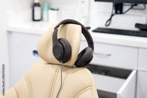 Dentist office treatment room has noise blocker headphones for the patient to relax with during teeth cleaning