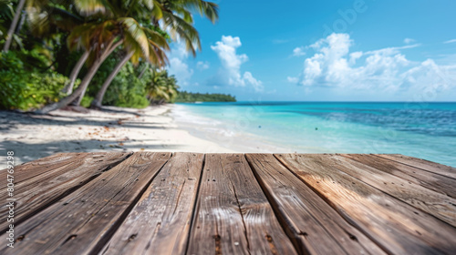Wooden deck overlooking a serene tropical beach with white sand, palm trees, and clear blue water.