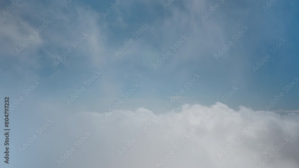 View of the blue sky while being above the clouds. Panorama of rushing clouds on a high mountain. View of the blue sky while being above the clouds. Panorama of rushing clouds on a high mountain.