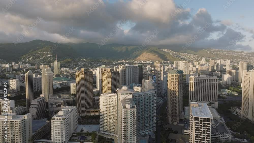 This aerial view captures the towering skyscrapers and urban landscape of Waikiki in Oahu, Hawaii. The citys impressive high-rise buildings dominate the skyline, showcasing its bustling urban core. This aerial view captures the towering skyscrapers and urban landscape of Waikiki in Oahu, Hawaii. The citys impressive high-rise buildings dominate the skyline, showcasing its bustling urban core.