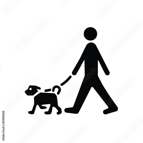 Silhouette of a person walking a dog on a leash.