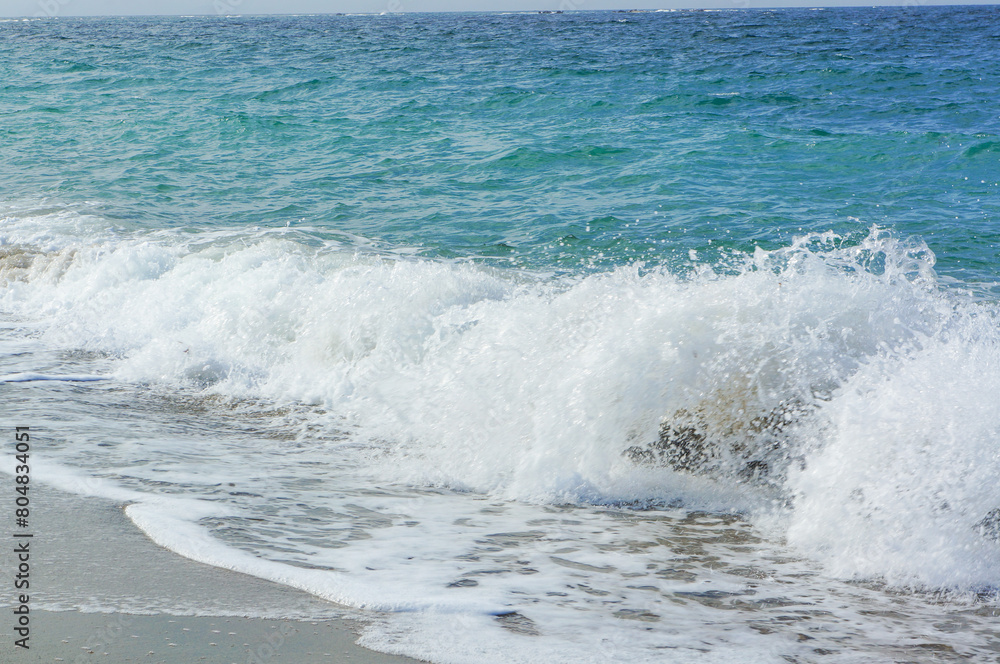 ビーチに勢いよく打ち寄せる波の景色