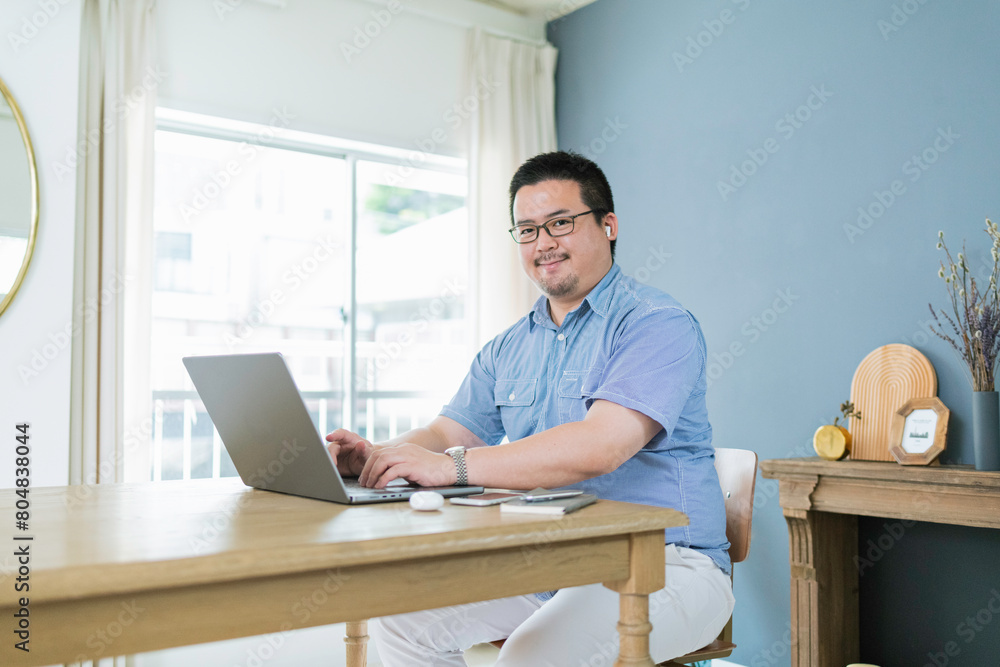 自宅でリモートワークをする大柄な日本人男性