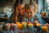 A mother and her daughter are lighting candles together
