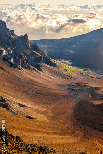 beautiful view of Haleakala volcano mountain on the morning sunrise create layers of slide sand between hills colorful over orange clouds sky background at Maui, Hawaii USA