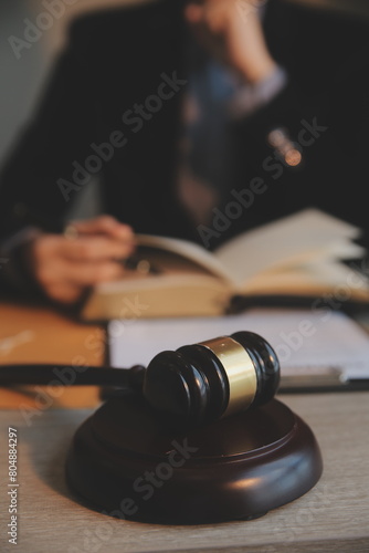 Business and lawyers discussing contract papers with brass scale on desk in office. Law, legal services, advice, justice and law concept picture with film grain effect