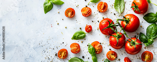 Fresh organic tomatoes and basil herb leaves on a white background with copy space.