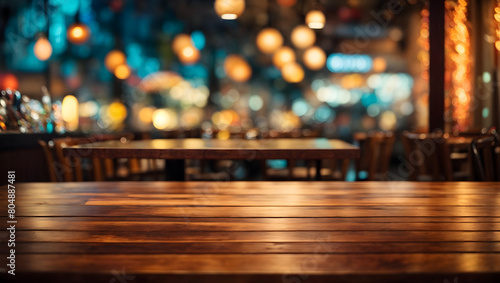 Image of empty wooden table in front of abstract blurred restaurant lights background