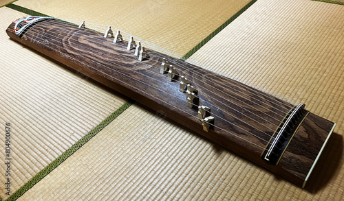 A Koto, a traditional 13 stringed instrument on the tatami mats of a Japanese-style room. The whole picture with a Koto pillar.