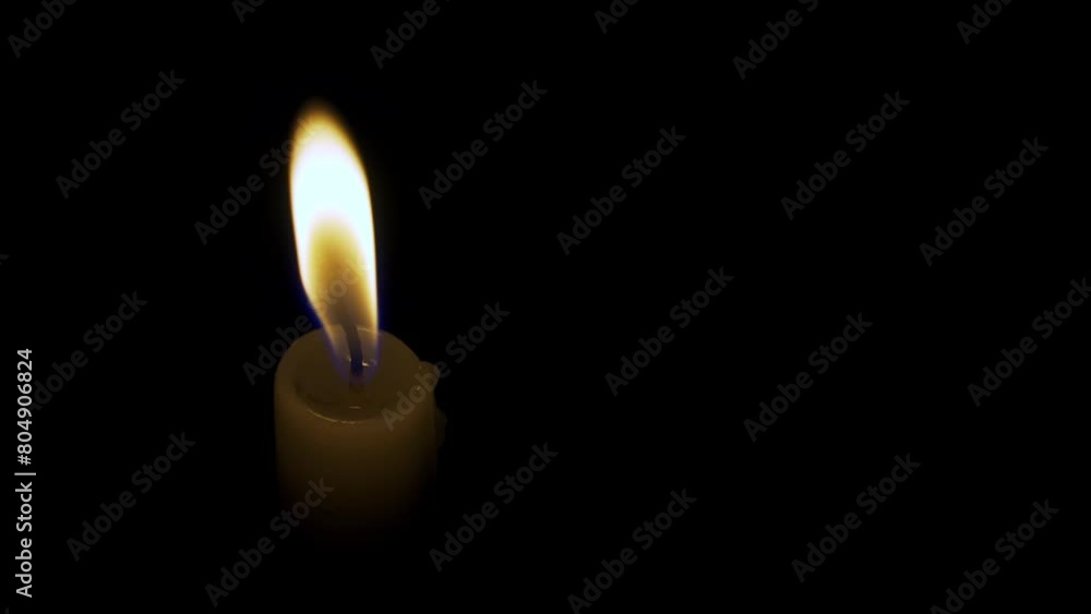 The flame of a wax candle lights up the darkness. Flashes of fire are reflected in the melted wax. A cozy atmosphere of tranquility. The concept of a religious ceremony, the mystery of death, grief. The flame of a wax candle lights up the darkness. Flashes of fire are reflected in the melted wax. A cozy atmosphere of tranquility. The concept of a religious ceremony, the mystery of death, grief.