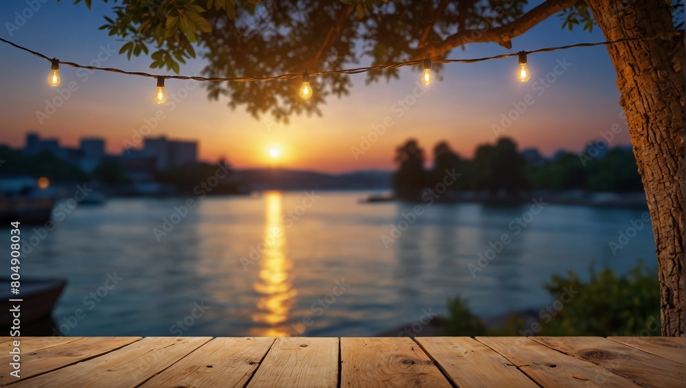 Empty Wood table top with decorative outdoor string lights hanging on tree in the garden , Daylight saving time end, real estate concept and blurred landscape of river beach Blue sky with sunset